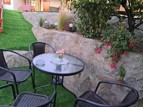 a table with chairs and a vase of flowers on it at Casa Vista del sol, con piscina, tinaja, y quincho in Caracha