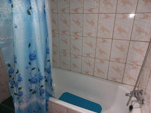 a bathroom with a tub and a shower curtain at Casa Vista del sol, con piscina, tinaja, y quincho in Caracha