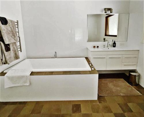 a white bathroom with a tub and a sink at Tantallon in Berry