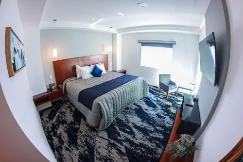 Habitación de hotel con cama y TV en Hotel Fray Select en Tepic