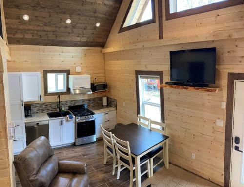 a kitchen with a table and a television in a cabin at Cougar Mountain Lodge and Resort Cabin Rentals in Valemount