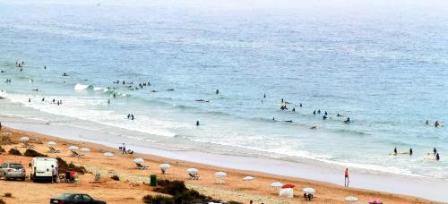 a group of people in the water at a beach at Tigmi surf morocco in Tiguemmi nʼAït Bihi