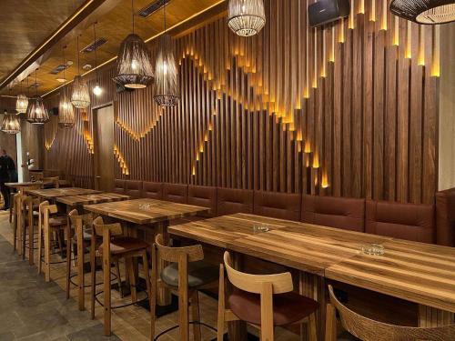 a restaurant with wooden tables and chairs and hearts on the wall at Apartman Drvorez-direktno na ski stazi in Jahorina