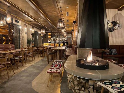 a restaurant with a fireplace in the middle of the room at Apartman Drvorez Jahorina in Jahorina
