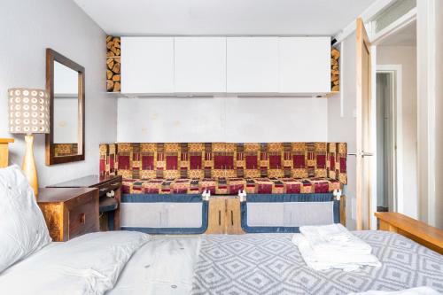 Schlafzimmer mit einem Bett und einer Bank in der Unterkunft Lovely 1-bedroom property with balcony in West end in Glasgow
