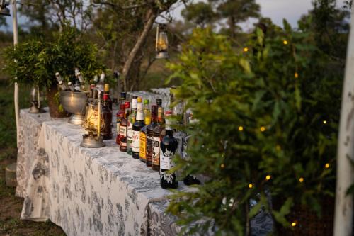 a long table with bottles of alcohol on it at Thornybush Game Lodge in Thornybush Game Reserve