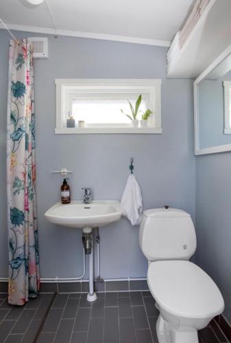 a bathroom with a toilet and a sink at Kræmmervikveien 33 in Ballstad