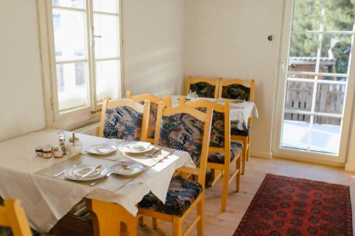 a dining room with a table and chairs and windows at Rösslgut Bed & Breakfast in Zederhaus