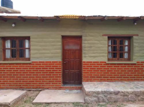 een huis met drie ramen en een deur bij Hosteria M.G in Tilcara