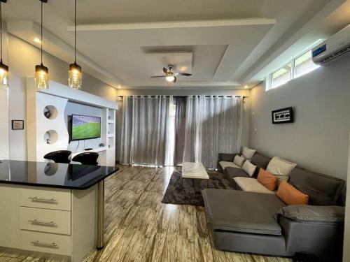 a living room with a couch and a tv at Meanwood Place Apartments in Lusaka
