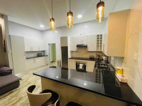 a large kitchen with a large black counter top at Meanwood Place Apartments in Lusaka
