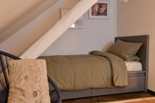 uma cama num quarto com corrimão de escada em Heimat Floral Ferienhaus em Wadgassen