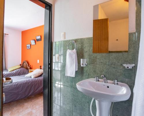 baño con lavabo y cama en Hostería Punta Sur en Lago del Desierto en El Chaltén