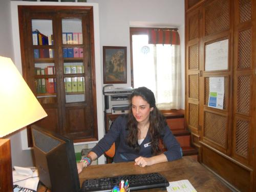 a woman sitting at a desk with a computer at Hotel Santa Isabel La Real in Granada