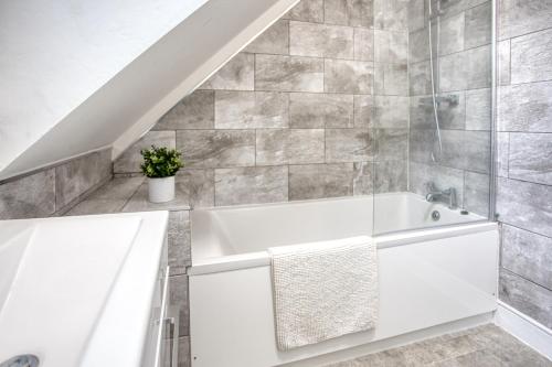 a white bath tub in a bathroom with a staircase at 1 or 2 bed in Folkestones West End in Folkestone