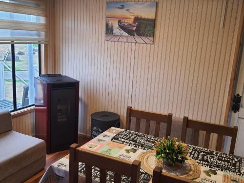 sala de estar con mesa, sillas, mesa y mesa en Cabaña Nothofagus PUQ, en Punta Arenas