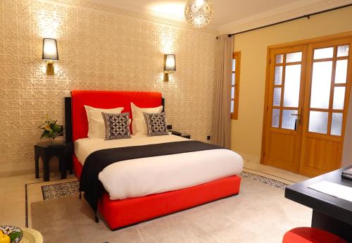 a bedroom with a large bed with a red headboard at Dar Lys Luxury Riad & Spa in Fès