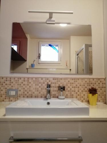 a bathroom with a white sink and a mirror at Casa in residence - Padenghe sul Garda in Padenghe sul Garda