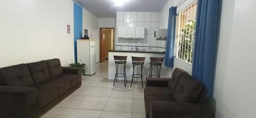 uma sala de estar com um sofá e uma cozinha em Casa do aconchego ( terreno compartilhado) em Foz do Iguaçu