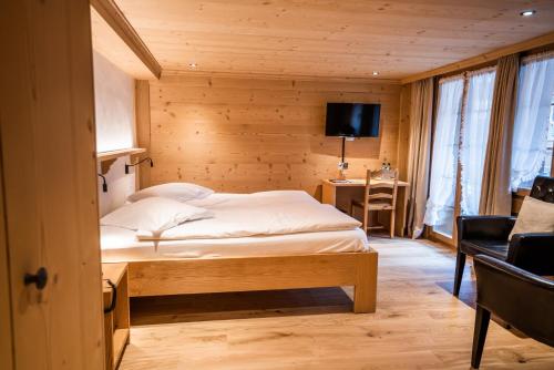 a bedroom with a bed in a wooden room at Posthotel Rössli in Gstaad