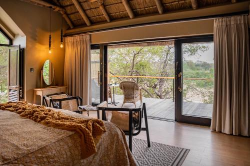 a bedroom with a bed and a sliding glass door at Thornybush Game Lodge in Thornybush Game Reserve
