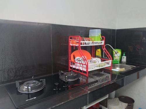 einem roten Wäscheständer neben einem Waschbecken in der Unterkunft Villa Adinda Syariah D8 in Tarogong