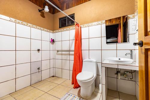 ein Bad mit einem WC und einem Waschbecken in der Unterkunft Whale Tail Hotel in Uvita