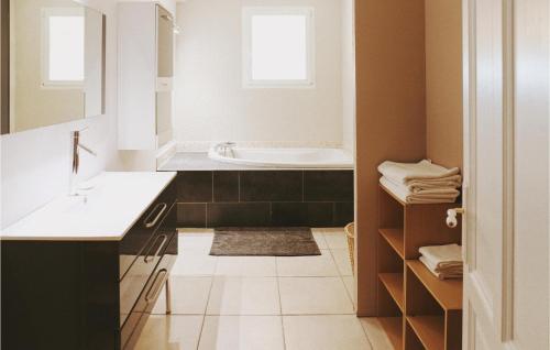 La salle de bains est pourvue d'un lavabo et d'une baignoire. dans l'établissement 3 Bedroom Amazing Home In Rochefort, à Rochefort-du-Gard