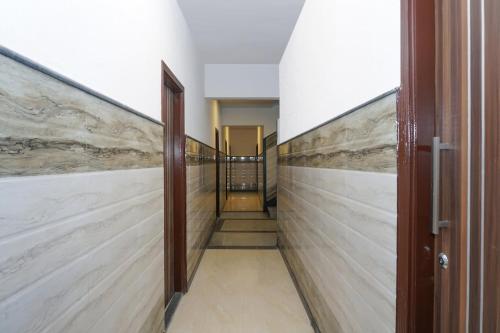 a hallway with marble walls and wooden doors at Flagship RK Residency in Sohāna