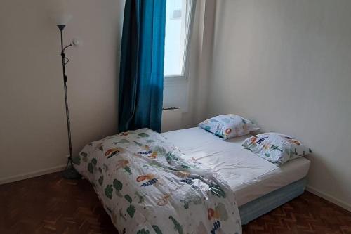 ein kleines Bett in einem Zimmer mit Fenster in der Unterkunft 3pièces stade de France Grand-Paris in Saint-Denis