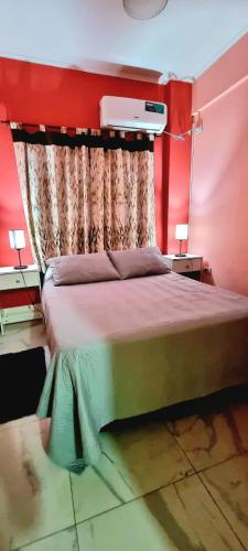 ein Schlafzimmer mit einem großen Bett mit einer roten Wand in der Unterkunft Providencia alquiler temporario-turístico in Paraná