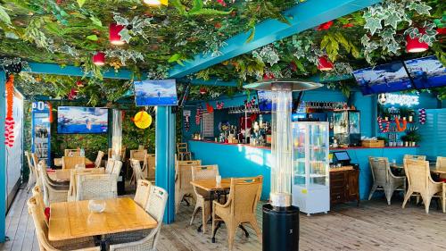 ein Restaurant mit Tischen und Stühlen und eine Bar in der Unterkunft Maszoperia Sun4hel Kite & Wind & Surf in Jastarnia