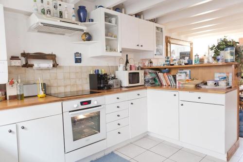 - une cuisine avec des armoires et des appareils blancs dans l'établissement Chambre chez l'habitant - proche du centre - salle d'eau et WC privés, à Bordeaux