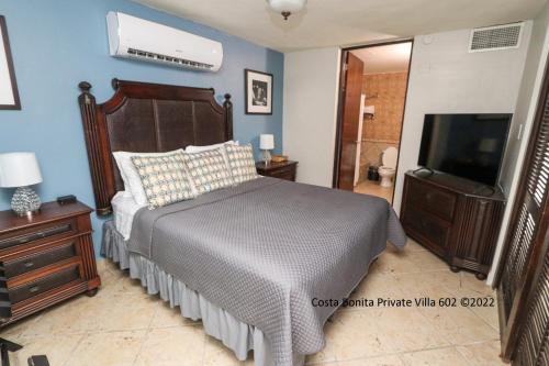 a bedroom with a bed and a flat screen tv at Costa Bonita Private Villa 602 in Culebra