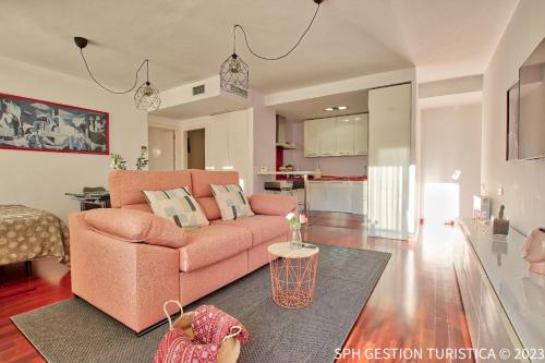 sala de estar con sofá rosa y cocina en Walker Apartamento Centro Murcia con parking privado en Murcia