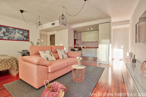 a living room with a pink couch and a kitchen at Walker Apartamento Centro Murcia con parking privado in Murcia