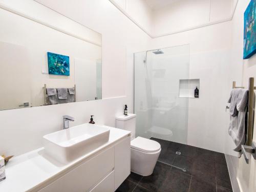 a white bathroom with a sink and a toilet at A Coonawarra Experience in Penola