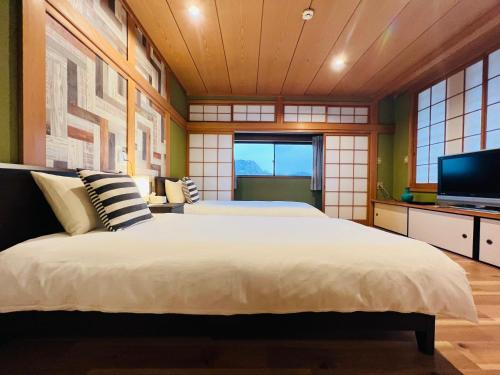 a bedroom with a large bed and a television at NARA japanese garden villa in Nara