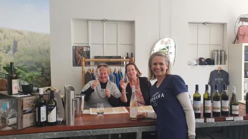 two women standing in front of a counter with wine bottles at A Coonawarra Experience in Penola