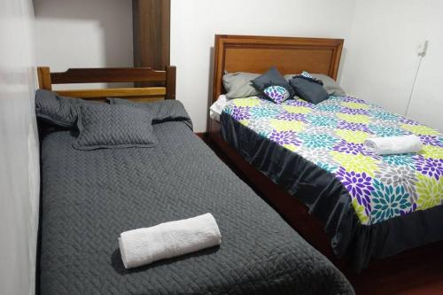 dos camas sentadas una al lado de la otra en un dormitorio en Cómodo y acogedor departamento en Baños, en Baños