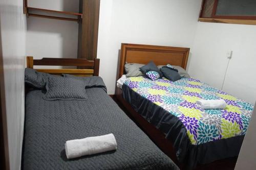 dos camas sentadas una al lado de la otra en un dormitorio en Cómodo y acogedor departamento en Baños, en Baños