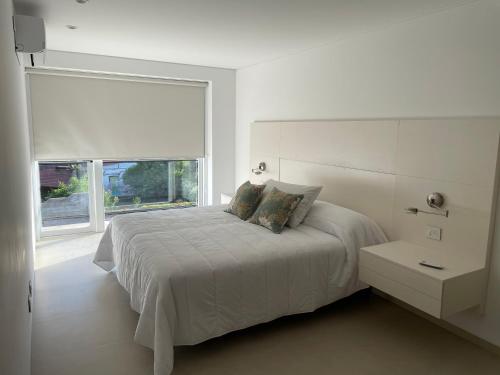 um quarto branco com uma cama e uma janela em ROCAS DEL PLATA 2 (Mendoza Capital) em Mendoza