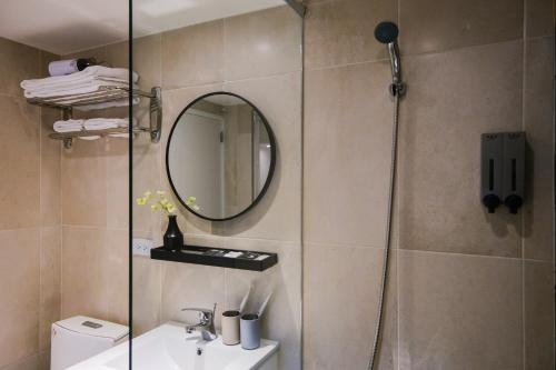 a bathroom with a shower with a sink and a mirror at Giant Rich Hotel in Taipei