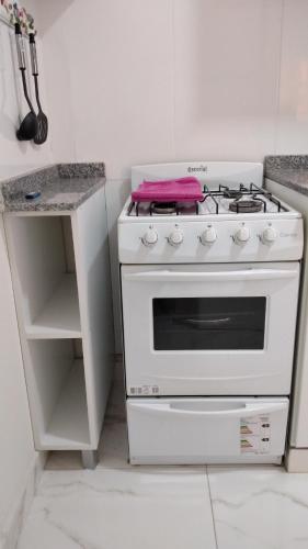 Una estufa blanca en una cocina con encimera en Departamento 51 TORRE PARIS en Resistencia