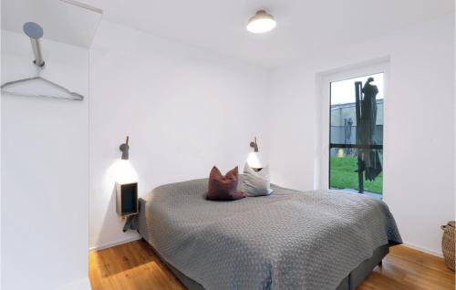 ein Schlafzimmer mit einem Bett mit Kissen und einem Fenster in der Unterkunft Pet Friendly Apartment In Lembruch-dmmer See With Kitchenette in Lembruch