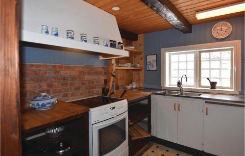 a kitchen with a sink and a stove top oven at Awesome Home In Dals Lnged With House Sea View in Dals Långed