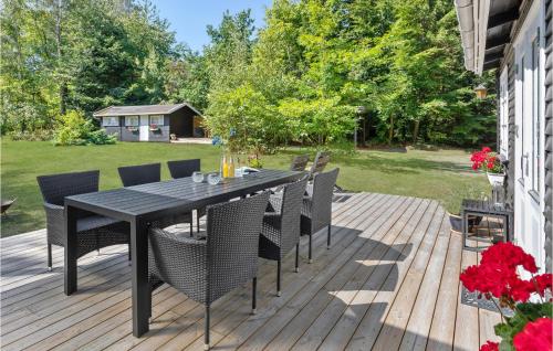 a wooden deck with a black table and chairs at 2 Bedroom Lovely Home In Rnne in Rønne