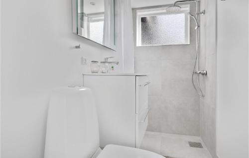 ein weißes Bad mit einem WC und einer Dusche in der Unterkunft 2 Bedroom Lovely Home In Rnne in Rønne