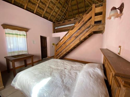 1 dormitorio con 1 cama y escalera de madera en Ecoturismo Cabañas La Florida, en Cardonal