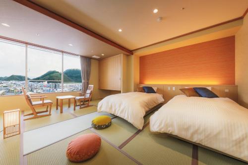 A bed or beds in a room at Tendo Hotel